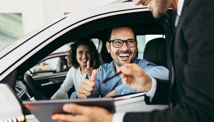 couple smiling in new car