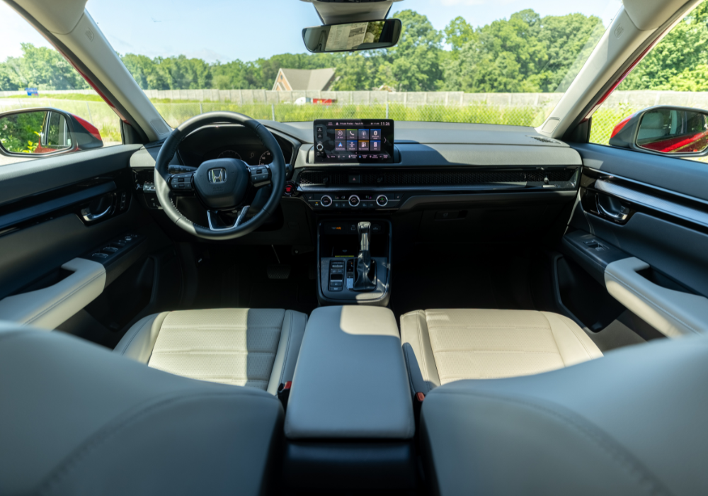 Stock photo of a red 2025 Nissan Rogue for sale. The photo shows the rear exterior of the car